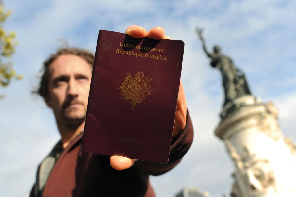 رجل يحمل جواز سفر فرنسي تعبير عبن الجنسية الفرنسية