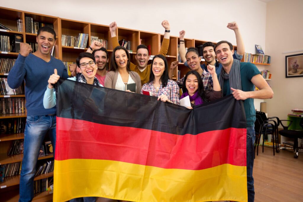 مجموعة من الطلاب الجامعيين يحملون علم ألمانيا- الدراسة في ألمانيا