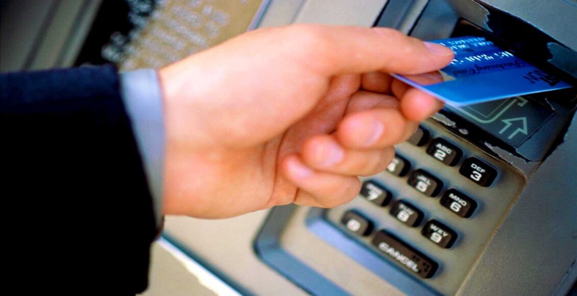 رجل يدخل بطاقة بنكية في الصراف الآلي - فتح حساب بنكي في النرويج