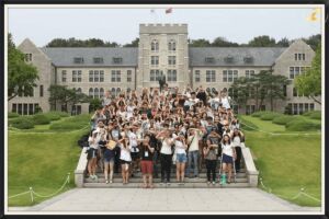 مجموعة من الطلاب يلتقطون صورة تذكارية  أمام مبنى جامعة الضيوف في كوريا