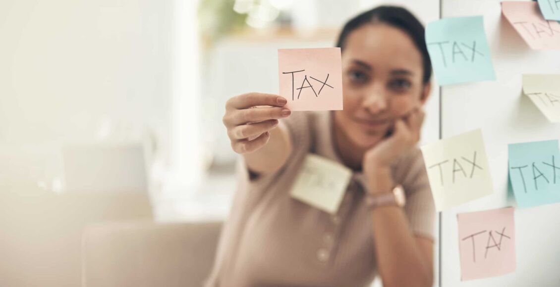 فتاة تحمل كورقة عليها كلمة ضريبة - نظام الضرائب في إسبانيا